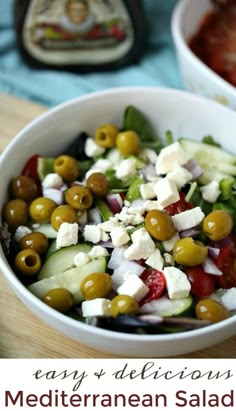 a salad with olives, cucumbers and feta cheese in a white bowl