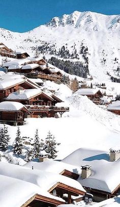 snow covered mountains and houses in the foreground