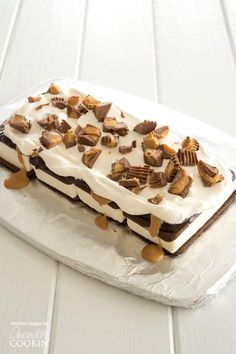 a piece of cake with white frosting and nuts on it sitting on top of plastic