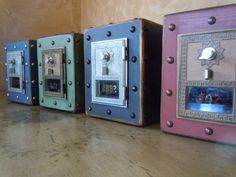 three different colored boxes with pictures on them sitting on a wooden table next to a wall