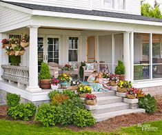 the front porch is decorated with flowers and potted plants