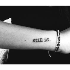 a woman's arm with a tattoo that says still is