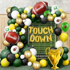 a football themed party with balloons, balls and a trophy in front of the sign that says touch down