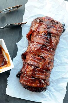 ribs on wax paper next to a bowl of bbq sauce