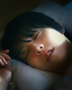 a close up of a child sleeping on a bed