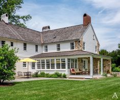 a large white house sitting on top of a lush green field