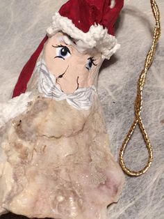 an ornament with a santa hat on it's head sitting on a piece of rock