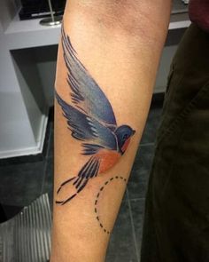 a small bird tattoo on the arm