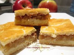 four pieces of pie sitting on top of a white plate with an apple in the background