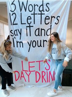 two girls holding up a sign that says, 3 words 12 letters say it and i'm your let's daydream