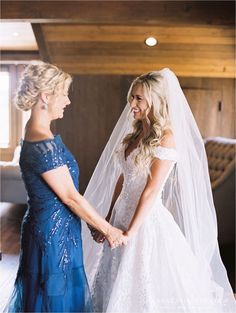 two women standing next to each other holding hands