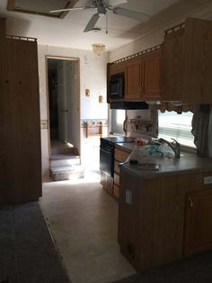 a kitchen with wooden cabinets and a ceiling fan