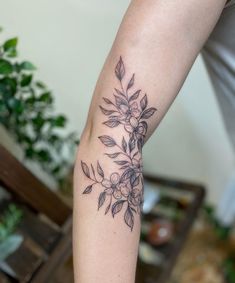 a woman's arm with a flower tattoo on the left side of her arm