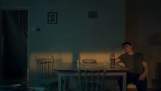 a man sitting at a table in the dark