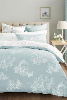 a bed with blue and white comforters in a bedroom