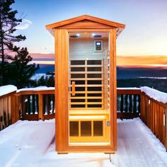 a wooden sauna sitting on top of snow covered ground