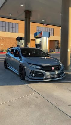 a gray car parked in front of a gas station