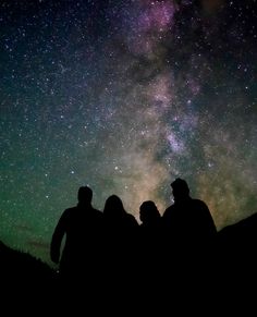 three people looking up at the night sky