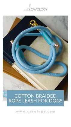 the cotton braided rope leash for dogs is shown on top of a book with a gold