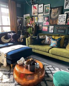 a living room filled with green couches and pictures on the wall above them,