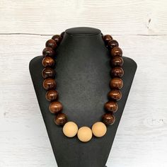 This chunky wood necklace was hand beaded using a mix of large 25mm round dark brown and 28mm round medium tone tan wooden beads in a modern color block design. The necklace measures 24 inches long and is securely fastened with a silver clasp.  Perfect for any gender!  Length can be adjusted if needed - just ask! Wood represents a sense of earthiness, spirituality, creativity, liberty, prosperity, health, and natural touch.  Perfect for meditation, prayer, yoga practices, and everyday wear!    C Brown Beaded Necklace With Large Round Beads, Brown Round Beaded Necklace With Large Beads, Wooden Jewelry With Large Round Beads, Brown Wooden Beads Round Jewelry, Brown Wooden Beads Jewelry, Handmade Brown Beaded Necklaces, Handmade Brown Round Beaded Necklaces, Brown Round Wooden Beads Jewelry, Brown Wooden Beaded Jewelry