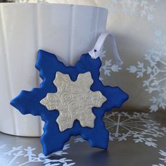 a blue and white snowflake ornament hanging from a cup