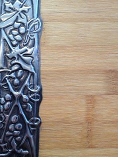 a decorative metal object sitting on top of a wooden table next to a bottle opener