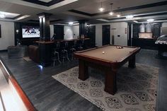 a game room with a pool table and bar