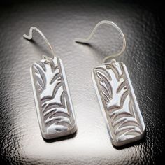 Beautiful FINE SILVER EARRINGS.  Each piece is handmade and my own unique design.   If you haven't heard of the process of working with Precious Metal Clay (PMC) it is intriguing and addicting.    The process includes: *Sculpting the jewelry design out of PMC. *Firing the piece.   This burns the organic material out of the clay leaving you with fine silver.  You can use a hand torch or kiln to fire the piece.  I only use a kiln now, as I can ensure the piece will be fully sintered.    *Then I refine and polish the final piece just for you.    These french loop ball and hoop earwires are handmade from Argentium Silver, which is known for being naturally nickel-free and hypoallergenic and is highly tarnish resistant. Please let me know if you have any questions.   :-) ~Denise Festive Artisan Silver Earrings, Nickel-free Artisan Earrings, Artisan Nickel-free Metal Earrings, Artisan Nickel-free Brass Earrings, Artisan Sterling Silver Nickel-free Chandelier Earrings, Precious Metal Clay, Argentium Silver, Metal Clay, Silver Earrings Dangle