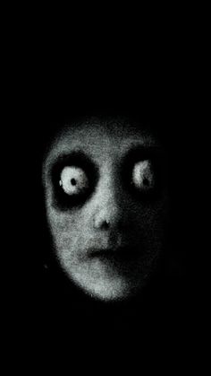 an evil looking person with big eyes in the dark