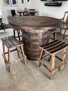 a large wooden barrel table with chairs around it