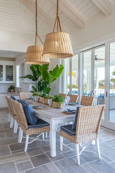 a dining room table with chairs and plants on it