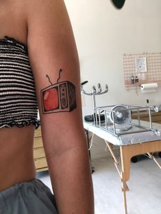 a woman with a tattoo on her arm that has an old tv on the screen