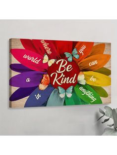 a colorful flower with the words be kind painted on it in different colors and sizes