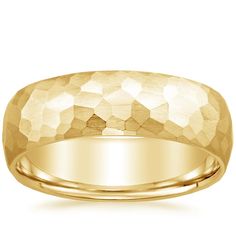 a yellow gold wedding ring with an irregular design on the inside, and a rounded surface