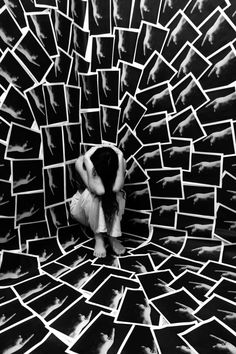 a person kneeling down in a room filled with pictures