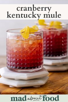 two glasses filled with cranberry kentucky mules on top of a white plate