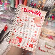 an open notebook with writing on it next to markers, pens and other crafting supplies