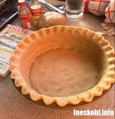 an uncooked pie crust sitting on top of a counter next to a bottle of water