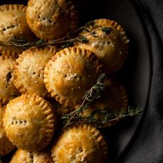 several small pastries on a plate with rosemary sprigs