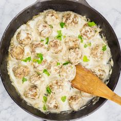 a skillet filled with meatballs and green onions