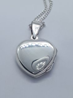 Stunning Heart Locket Sterling Silver Necklace. This beautiful pendant has been made in solid 925 sterling silver. This pendant will make a beautiful any occasion gift. Sterling silver chain is also included in the price. Pendant will be shipped to you in an elegant gift box. A tracking shipping number will be provided to you once necklace has been mailed. Locket  Pendent Measurements: 1.00 x 0.60 inches Sterling Silver Chain:  20 inches Materials: 925 Sterling Silver  Weight: 5.3 Gram Thanks fo Silver Sterling Silver Locket Necklace For Valentine's Day, Valentine's Day Silver Sterling Silver Locket Necklace, Valentine's Day Silver Sterling Locket Necklace, Silver Locket Necklace Pendant For Valentine's Day, Silver Pendant Locket Necklace For Valentine's Day, Silver Round Locket Necklace For Valentine's Day, Silver Locket Necklace For Valentine's Day, Silver Sterling Silver Heart Pendant Locket Necklace, Silver Hallmarked Pendant Locket Necklace