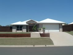 a house that is on the side of a road with grass in front of it