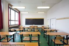 an empty classroom with wooden desks and chairs