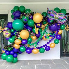 balloons and streamers decorate the entrance to a mardi gras party