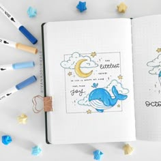 an open notebook with drawings and crayons around it