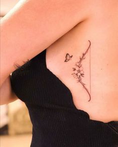 a woman with a butterfly tattoo on her back shoulder and arm, holding a flower