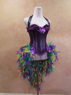 a mannequin with purple, green and yellow feathers on it's torso