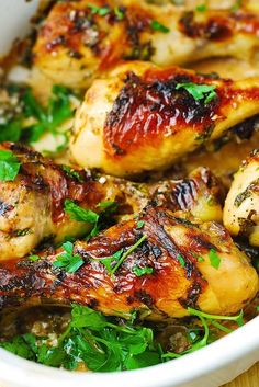 chicken with herbs in a white dish on a wooden table