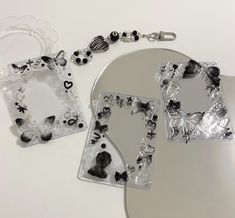 two pieces of jewelry sitting on top of a white table next to a mirror and keychain